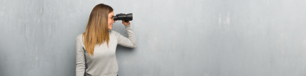 Stockfoto: Eine junge Frau, die durch ein Fernglas schaut